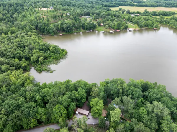 an aerial view of a residential houses with outdoor space and lake view