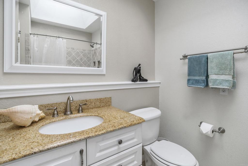 306 Fowles Street Oceanside, CA 92054 - Photo 14 of 29 a bathroom with a granite countertop toilet sink and mirror