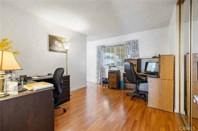 a view of a workspace with furniture and a window