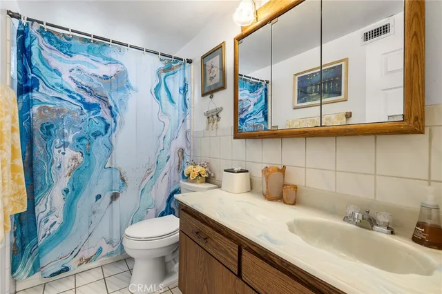 a bathroom with a sink a toilet and shower curtain