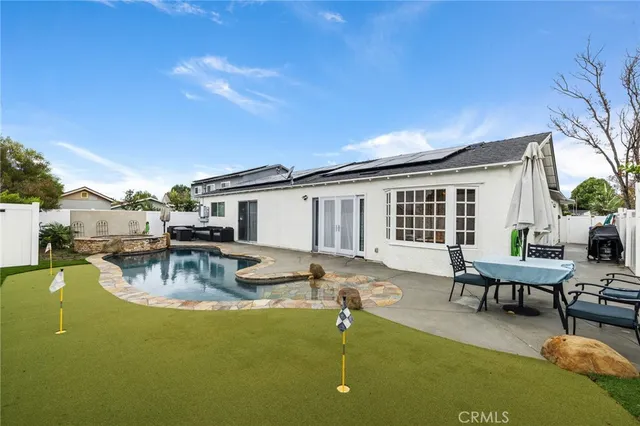 a view of a house with swimming pool and sitting area