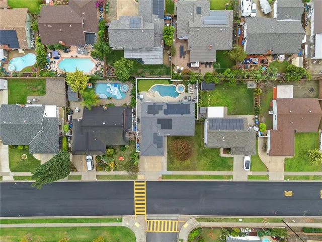 an aerial view of residential houses with outdoor space and parking