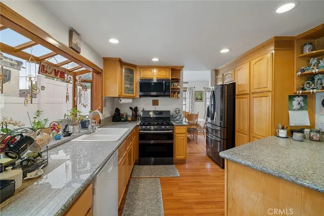 a kitchen with stainless steel appliances granite countertop sink stove and refrigerator