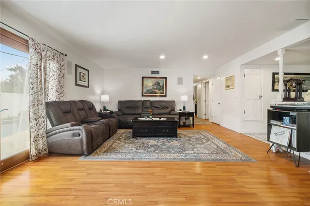 a living room with furniture and a wooden floor