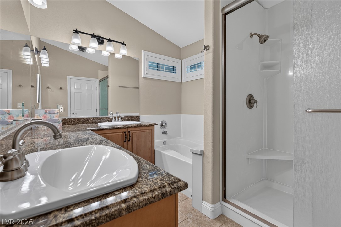 818 Manor Shores Road Henderson, NV 89002 - Photo 20 of 35 Granite counters and vaulted ceilings elevate this bathroom's sophisticated design.