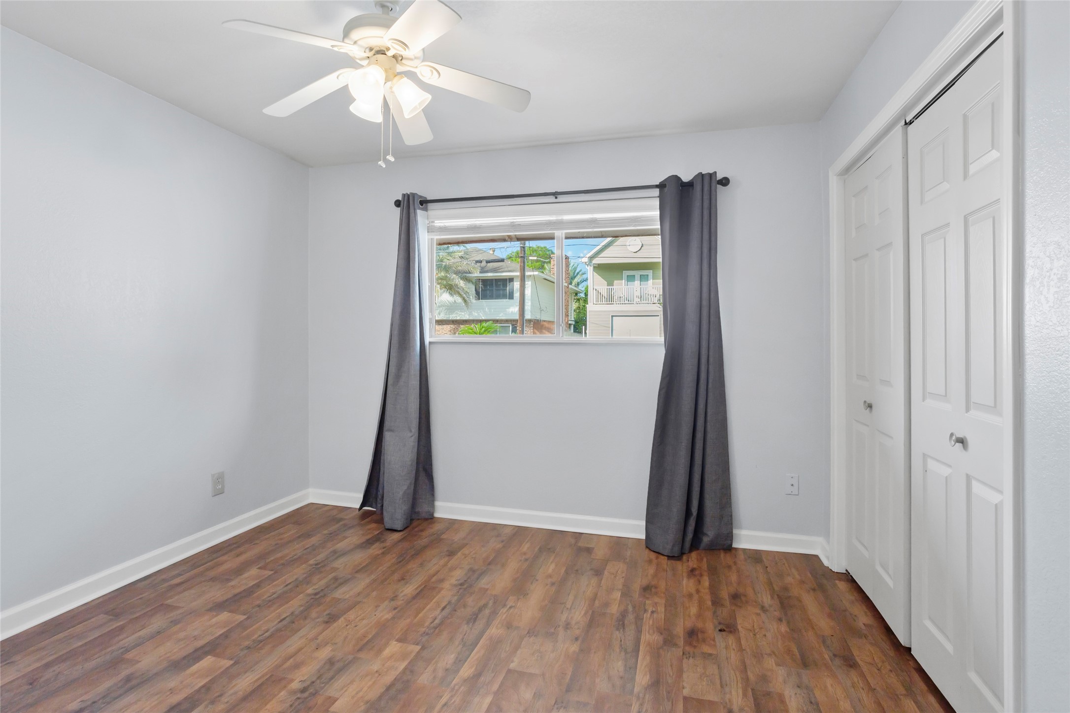 16 Harbor Lane Kemah, TX 77565 - Photo 22 of 31 an empty room with wooden floor chandelier fan and windows