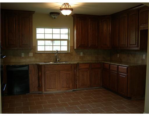 5325 Crestwick Drive Corpus Christi, TX 78413 - Photo 2 of 3 a kitchen with granite countertop a stove a sink and a window