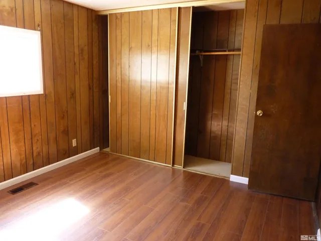 an empty room with wooden floor and windows with wooden floor
