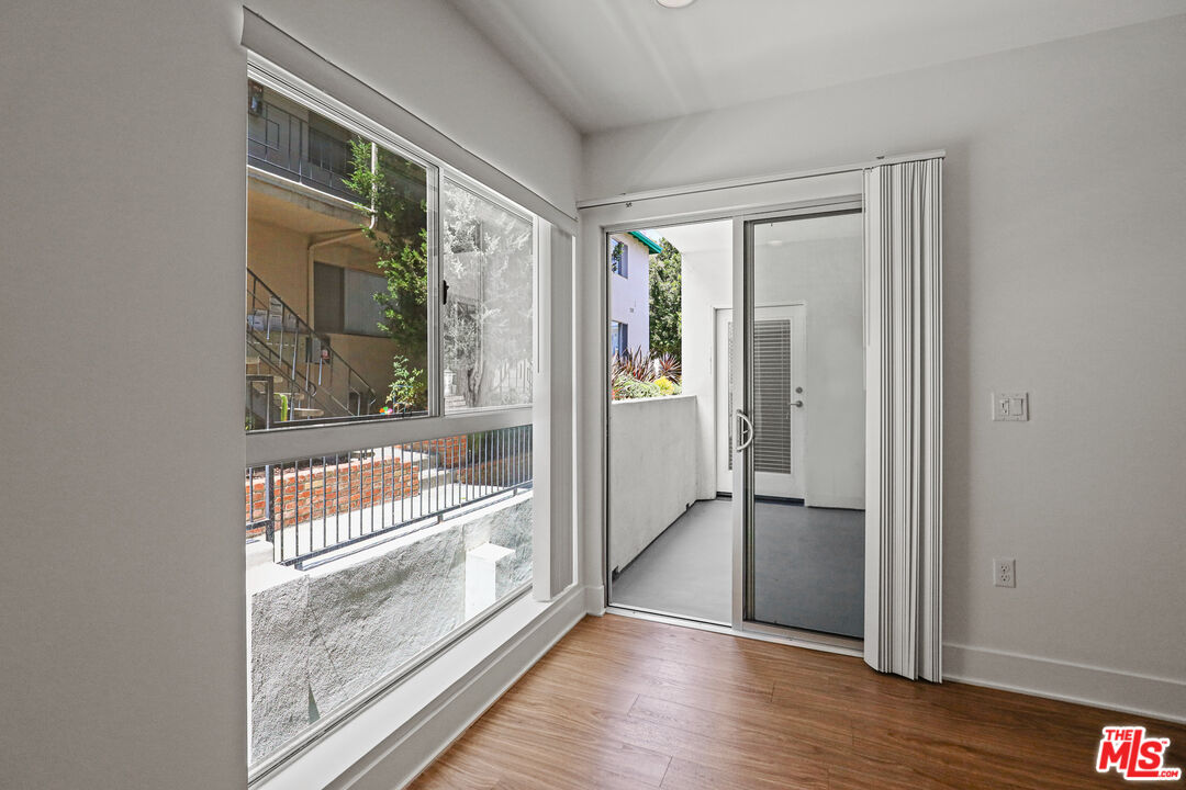 1411 Barry Avenue, Unit 306 Los Angeles, CA 90025 - Photo 5 of 14 a view of front door and bedroom with wooden floor