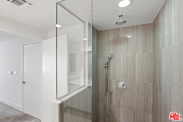 a bathroom with a shower and a glass door