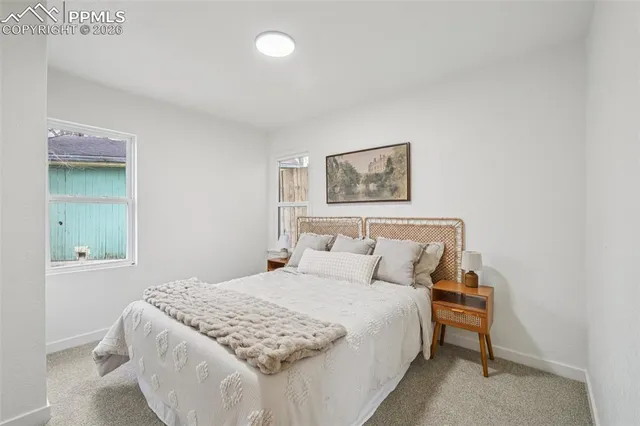 a bedroom with a bed and a painting on the wall