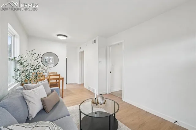 a living room with furniture a clock and a window