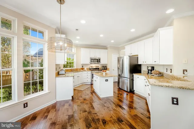 a kitchen with a sink a counter top space stainless steel appliances and cabinets