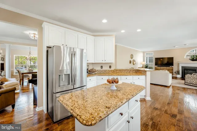 a kitchen with stainless steel appliances granite countertop sink refrigerator and cabinets