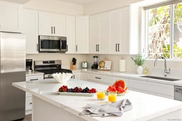 a large kitchen with a large window and stainless steel appliances