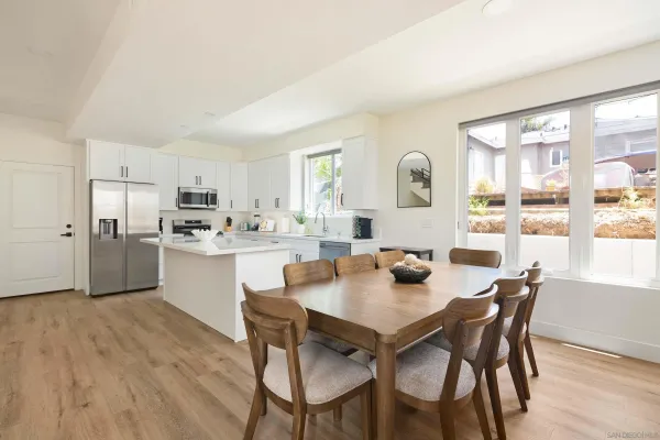 a dining room with kitchen island a table and chairs in it