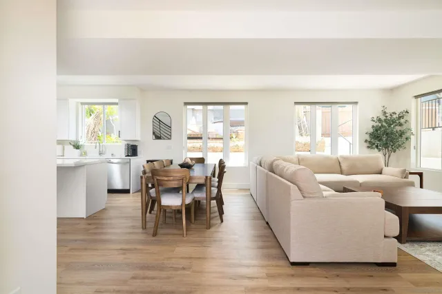 a living room with furniture wooden floor and a large window