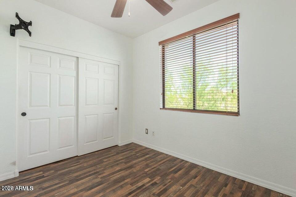 9551 East Redfield Road, Unit 1008 Scottsdale, AZ 85260 - Photo 15 of 19 a view of an empty room with wooden floor and a window
