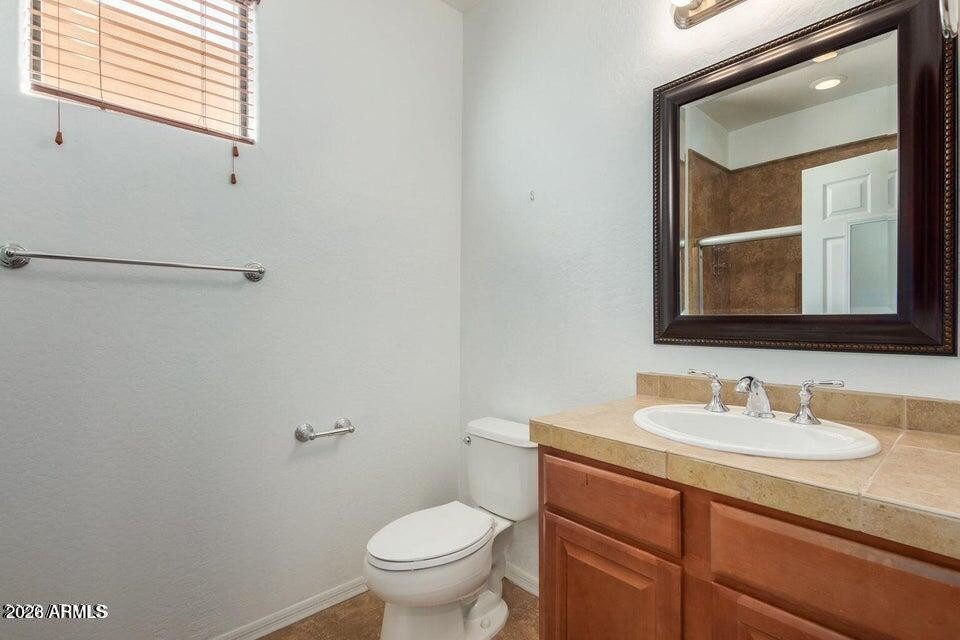 9551 East Redfield Road, Unit 1008 Scottsdale, AZ 85260 - Photo 17 of 19 a bathroom with a toilet sink and mirror