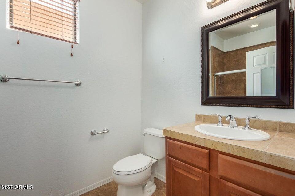 9551 East Redfield Road, Unit 1008 Scottsdale, AZ 85260 - Photo 17 of 19 a bathroom with a toilet sink and mirror