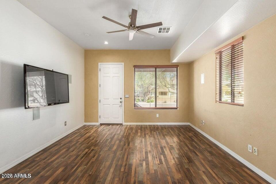 9551 East Redfield Road, Unit 1008 Scottsdale, AZ 85260 - Photo 8 of 19 a view of empty room with wooden floor and fan