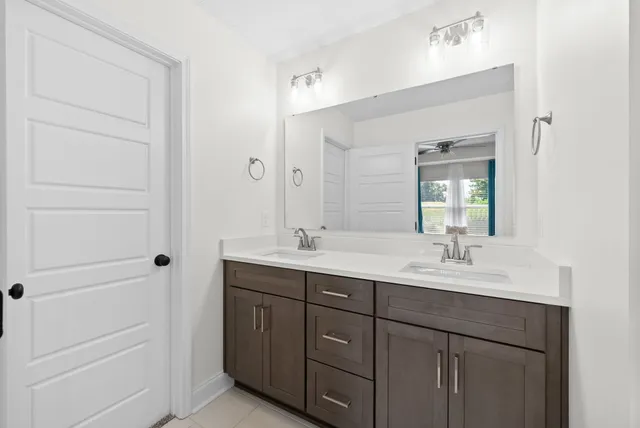 a bathroom with a double vanity sink toilet and a mirror