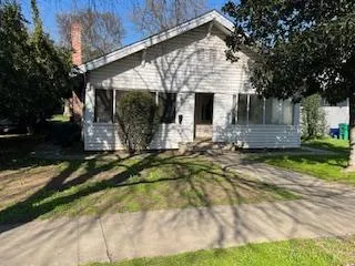 a view of house with backyard and sitting area