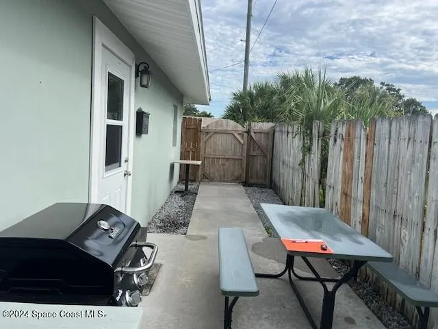 a backyard of a house with barbeque oven table and chairs