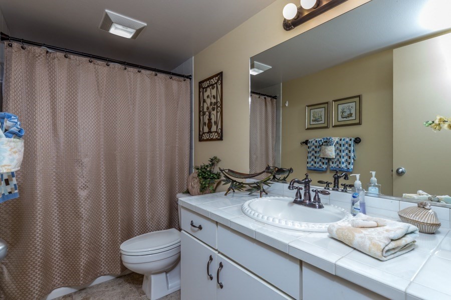 68-1745 Waikoloa Road, Unit L101 Waikoloa, HI 96738 - Photo 12 of 27 a bathroom with a granite countertop sink and a mirror