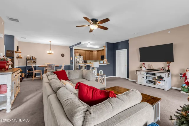 a living room with furniture kitchen view and a flat screen tv