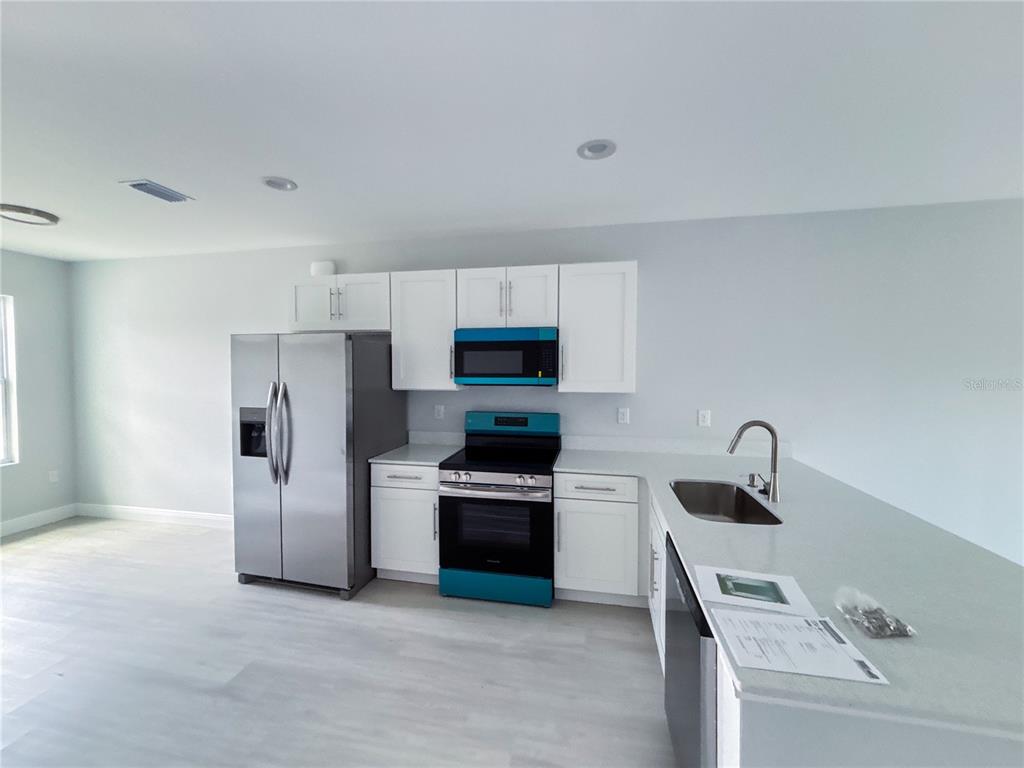 12 Trout Way, Unit A Kissimmee, FL 34759 - Photo 3 of 8 a kitchen with refrigerator and oven