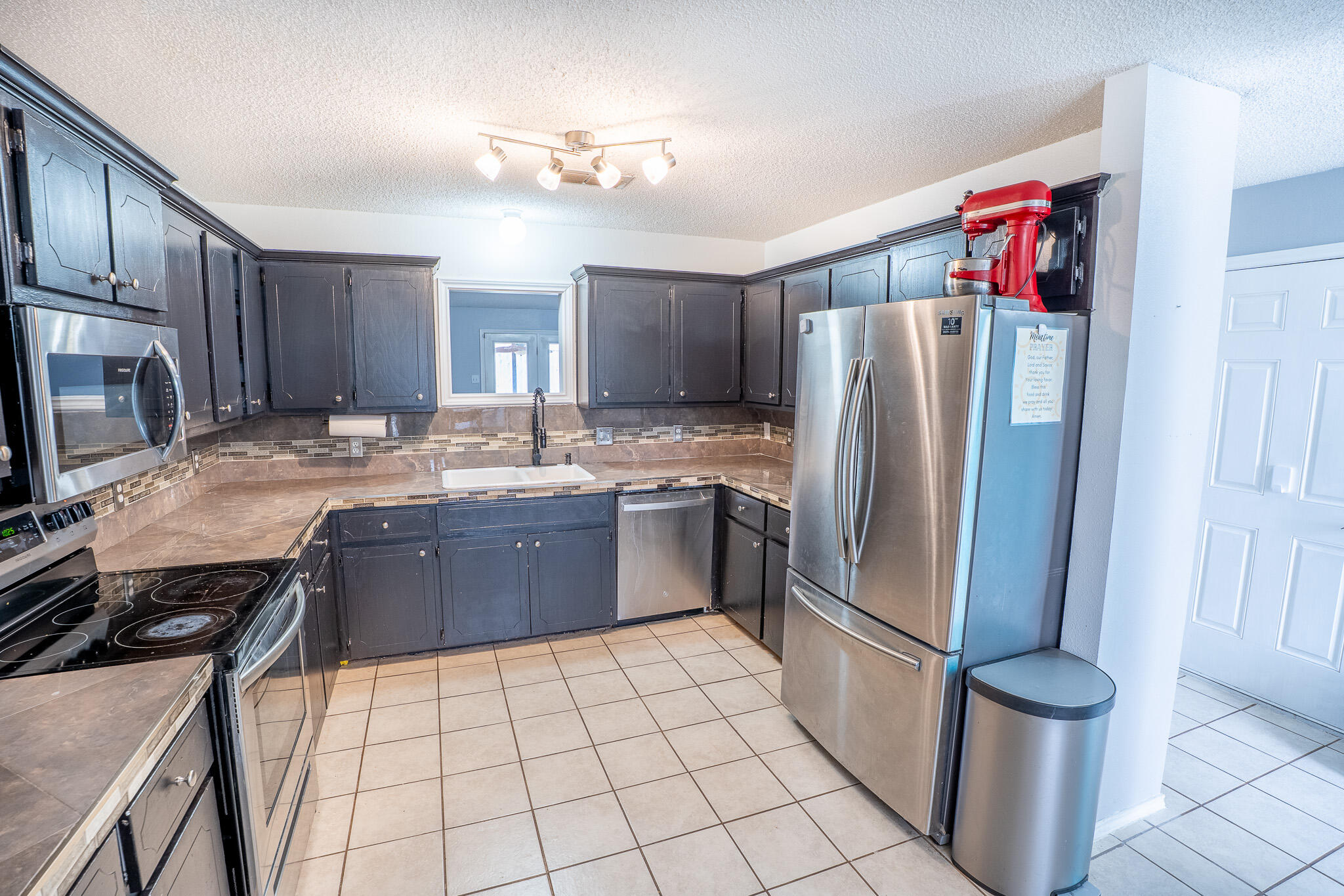 1609 78th Street Lubbock, TX 79423 - Photo 8 of 36 a kitchen with stainless steel appliances granite countertop a refrigerator a stove and a sink