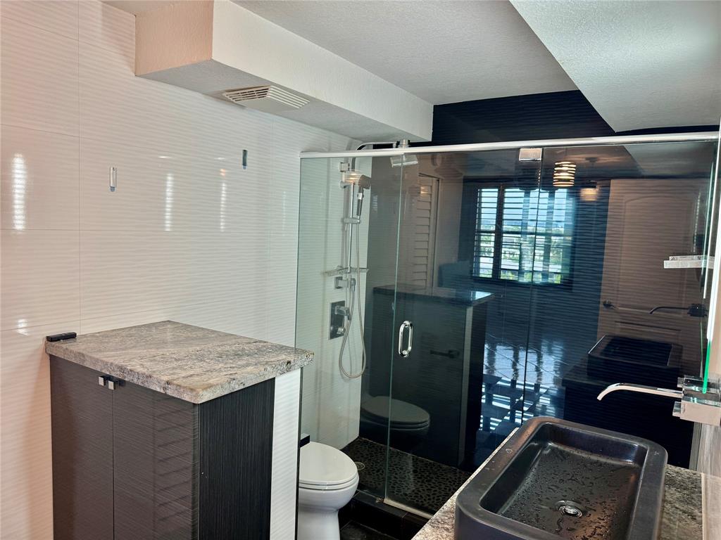 13 Royal Palm Way, Unit 5050 Boca Raton, FL 33432 - Photo 14 of 31 a bathroom with a granite countertop sink a toilet a mirror and shower