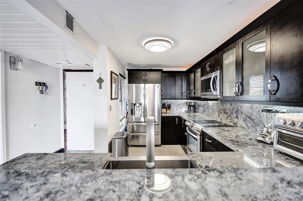 13 Royal Palm Way, Unit 5050 Boca Raton, FL 33432 - Photo 9 of 31 a kitchen with stainless steel appliances granite countertop a sink stove and refrigerator