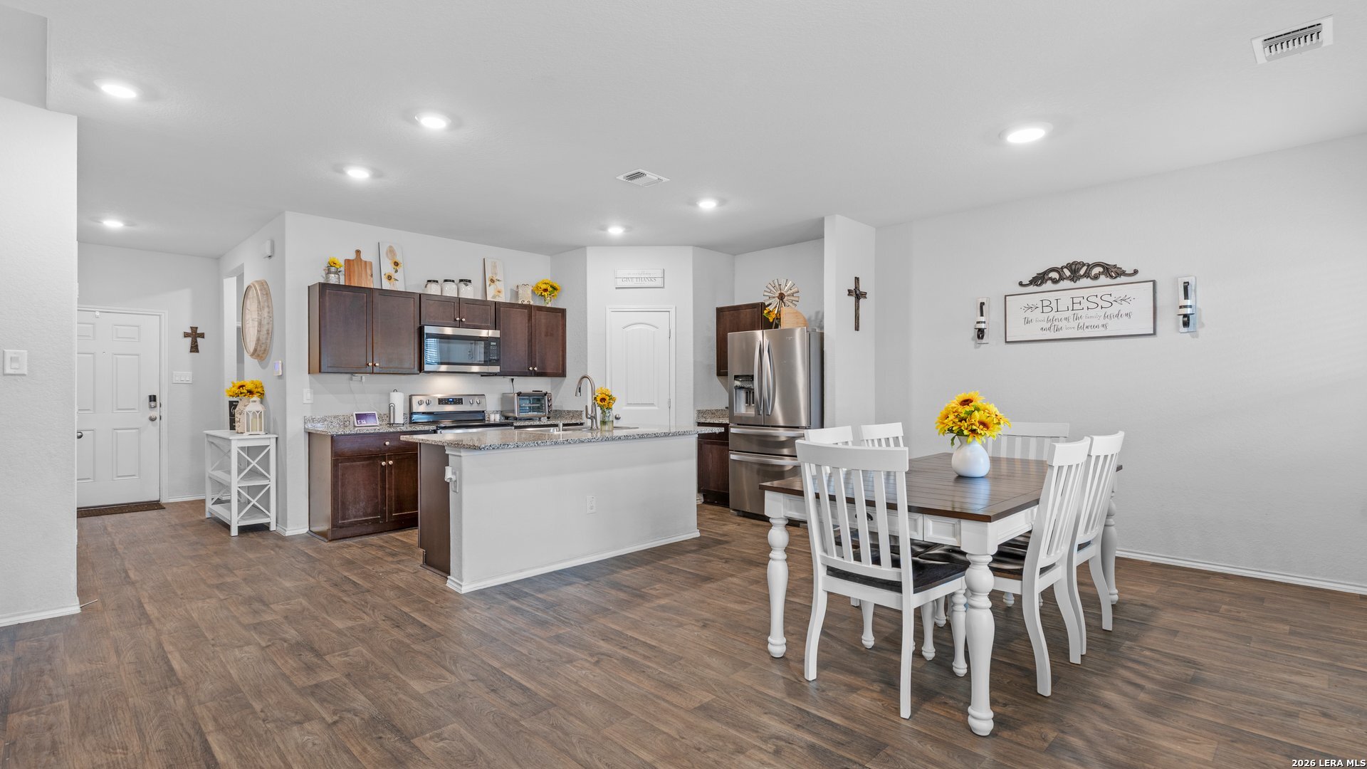 731 Monarch Drive Seguin, TX 78155 - Photo 6 of 21 a kitchen with a dining table chairs refrigerator and microwave