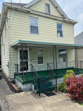 a view of a house with a yard and sitting area