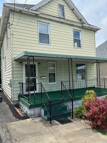 a view of a house with a yard and sitting area