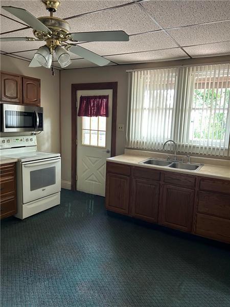 104 Whyle Avenue Uniontown, PA 15401 - Photo 5 of 12 a kitchen with kitchen island granite countertop a stove a sink and a microwave