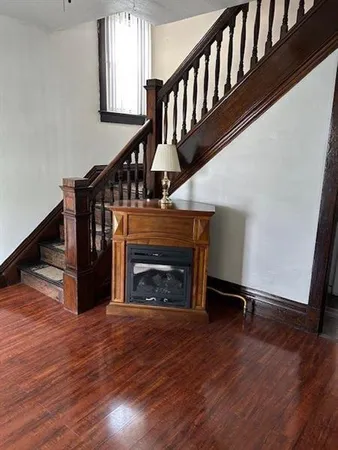 a view of an empty room with a window and a kitchen