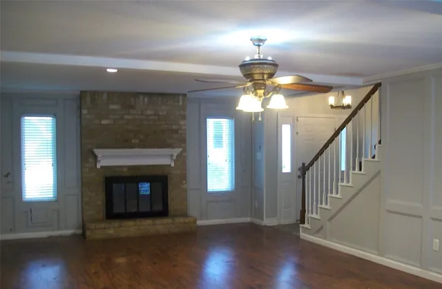 a view of a livingroom with a fireplace chandelier fan and windows