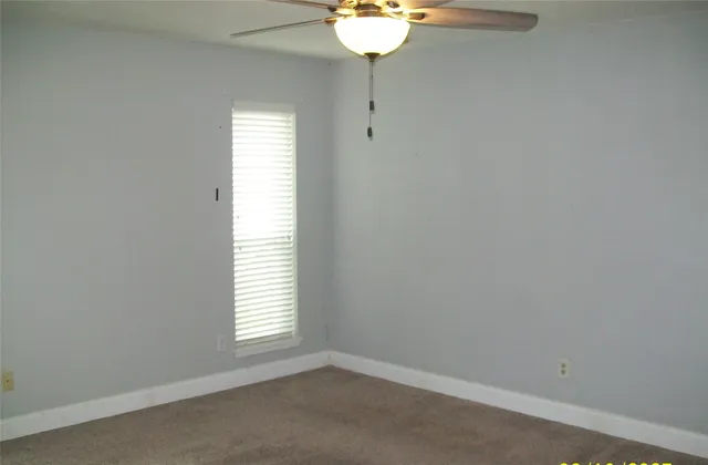 a view of a room that has a window and a wooden floor