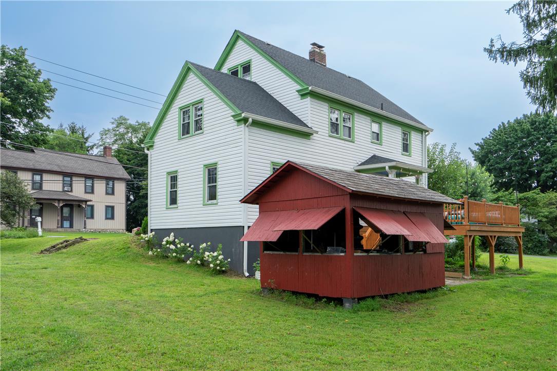 665 Point Phillips Road Bath, PA 18014 - Photo 65 of 73 A classic two-story residence with crisp white siding and vibrant green trim features a welcoming rear deck and a charming red shed.
