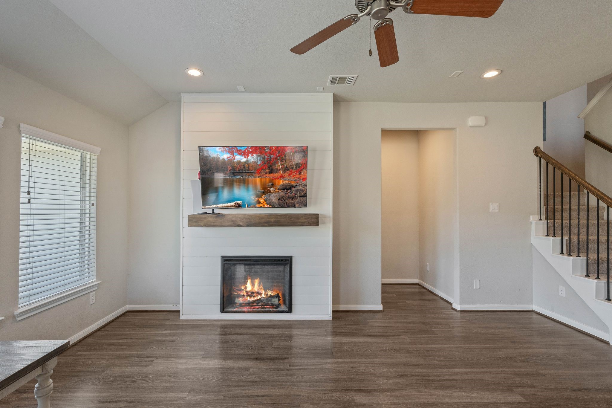2328 Hagerman Road Conroe, TX 77384 - Photo 14 of 45 a view of an empty room with wooden floor fireplace and a window