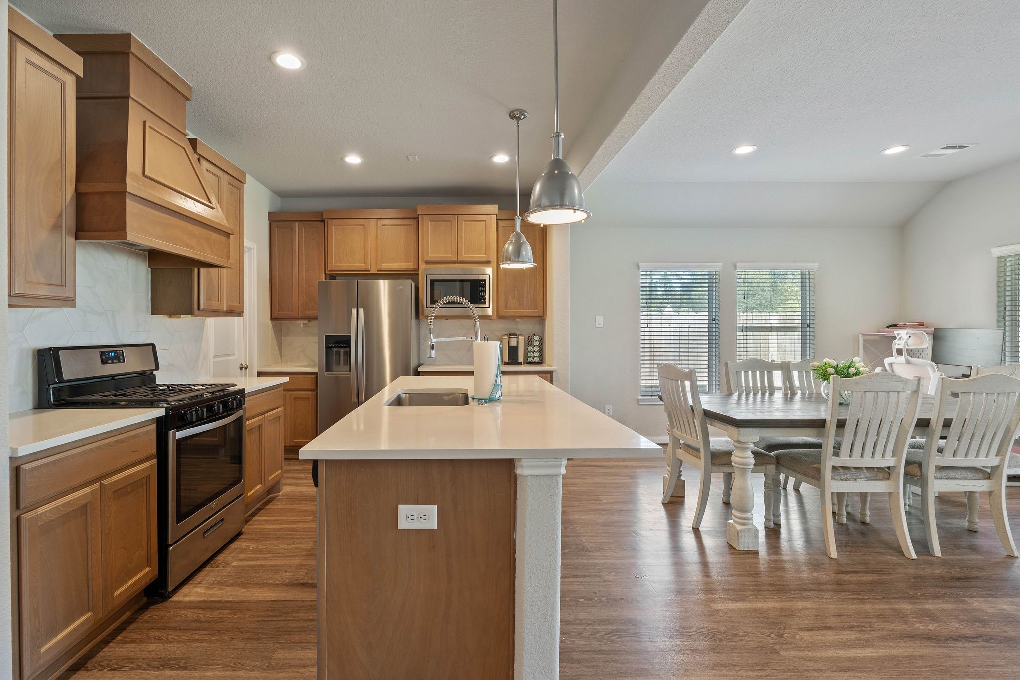 2328 Hagerman Road Conroe, TX 77384 - Photo 18 of 45 a large kitchen with stainless steel appliances granite countertop a stove a refrigerator a kitchen island a table and chairs