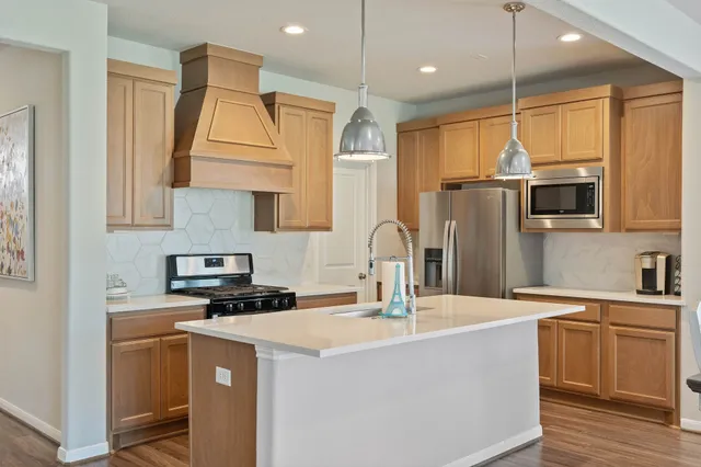 a kitchen with kitchen island a sink appliances and cabinets