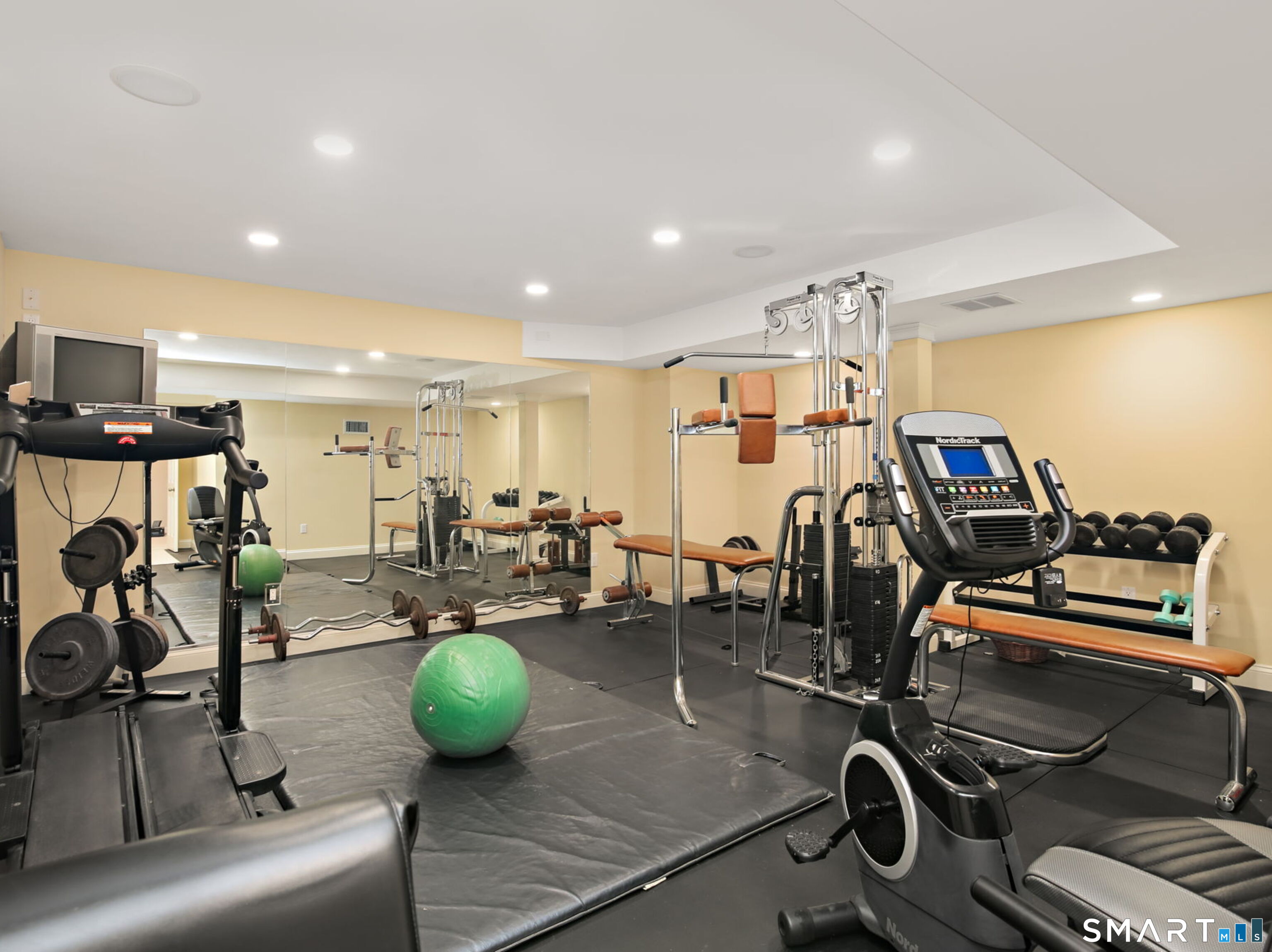 7 Long Meadow Lane Redding, CT 06896 - Photo 2 of 38 Dedicated fitness area within the finished lower level, featuring mirrored walls, rubber flooring, and ample space for equipment