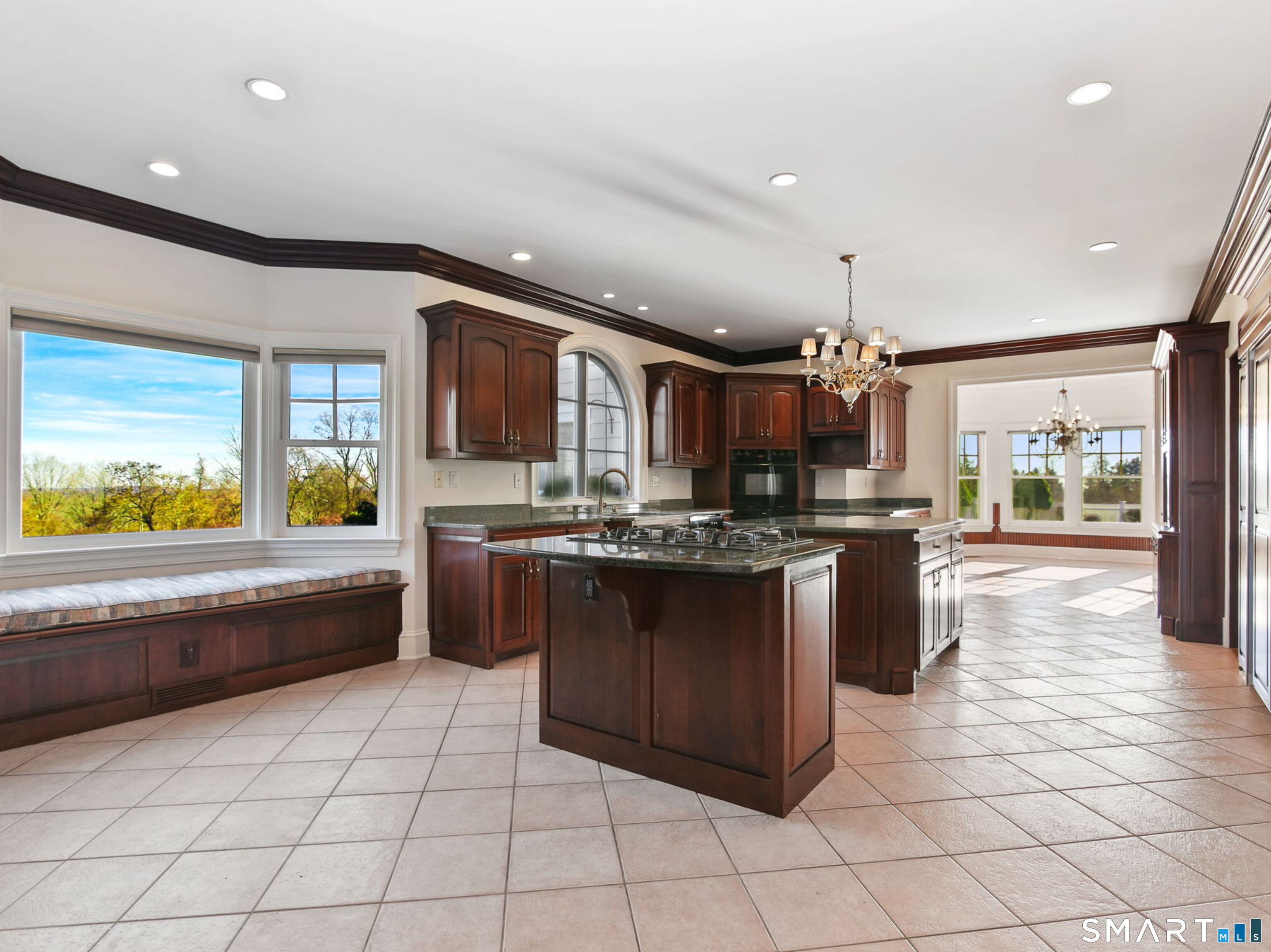 7 Long Meadow Lane Redding, CT 06896 - Photo 23 of 38 Expansive kitchen with center island, gas cooktop, custom cabinetry, and a built-in window seat overlooking the grounds
