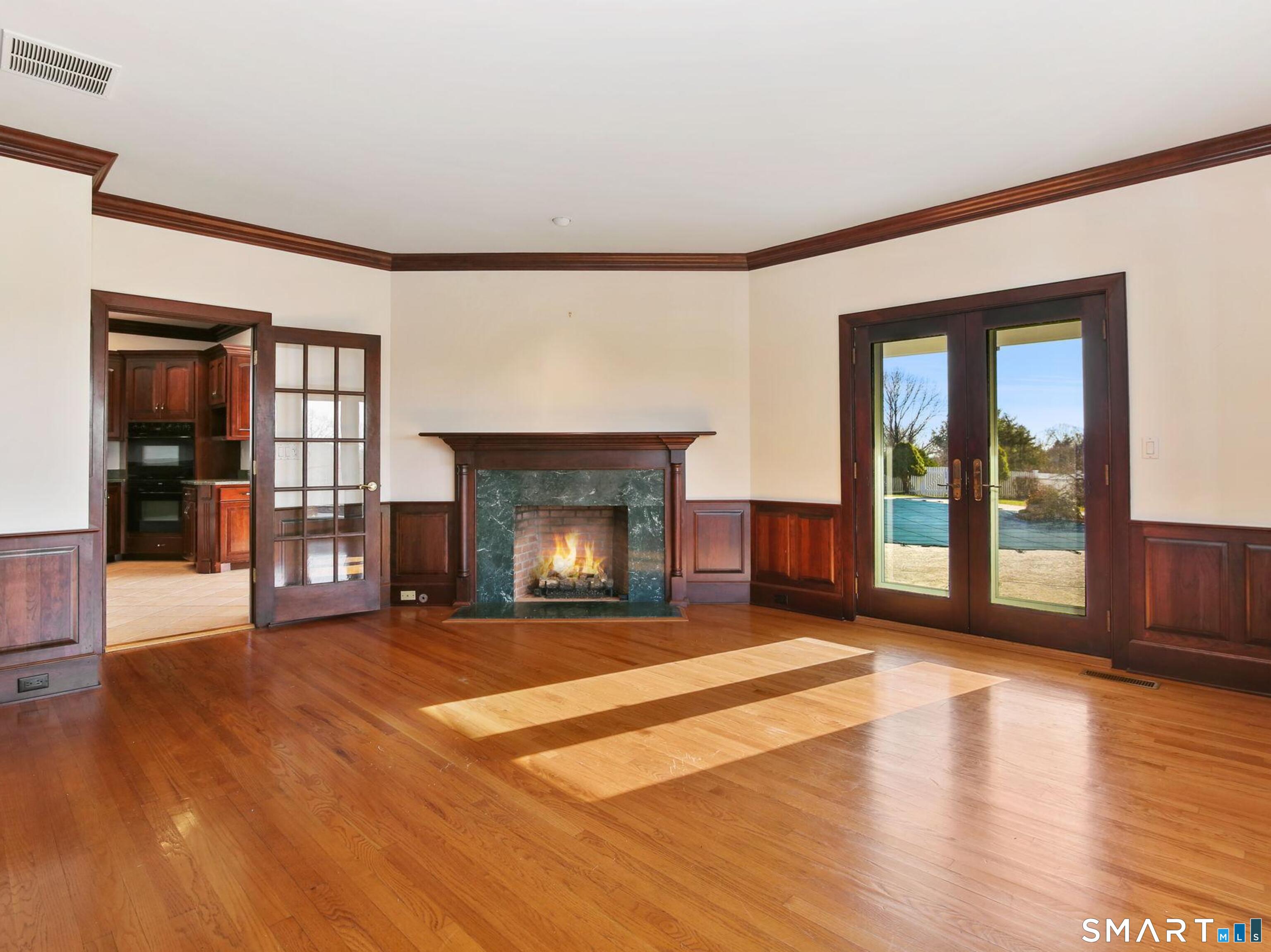 7 Long Meadow Lane Redding, CT 06896 - Photo 28 of 38 Elegant home office or library featuring rich millwork, a fireplace, and French doors opening to the outdoors-quiet, refined, and inspiring