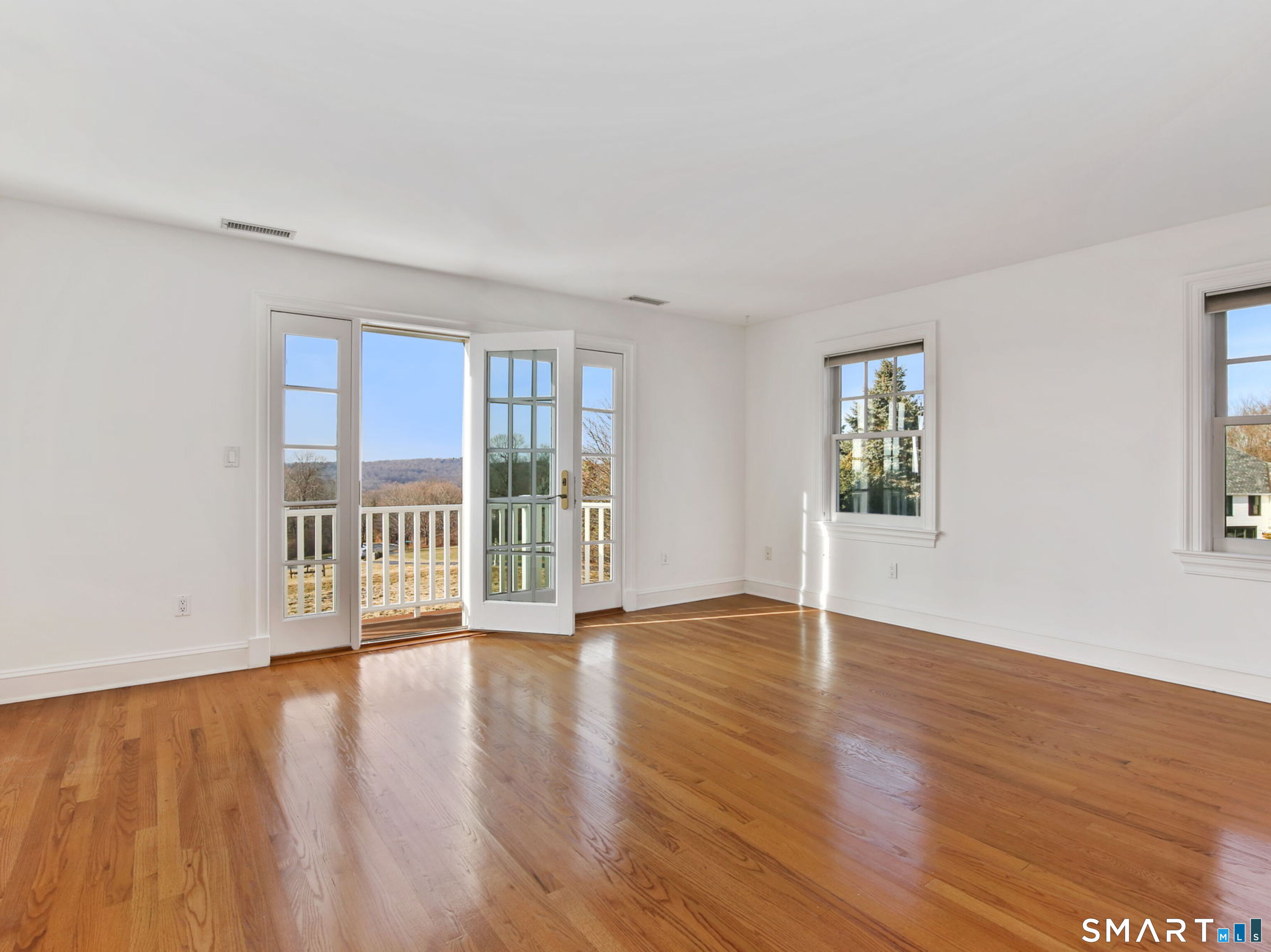 7 Long Meadow Lane Redding, CT 06896 - Photo 32 of 38 Light-filled bedroom suite with hardwood floors, bay windows, and a private balcony overlooking the grounds