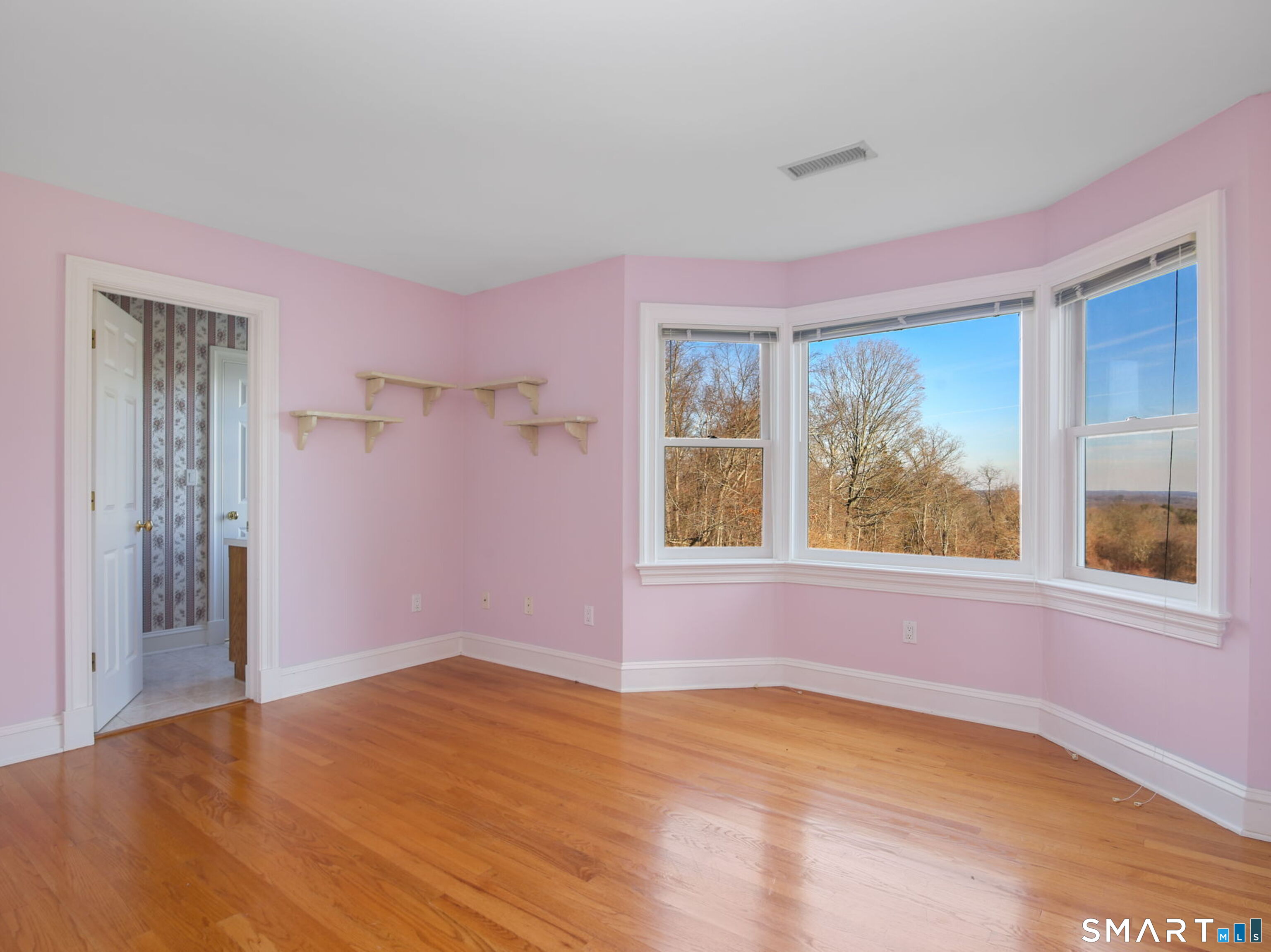 7 Long Meadow Lane Redding, CT 06896 - Photo 33 of 38 Bright bedroom with hardwood floors, bay-style windows, and sweeping views, connected to a shared bathroom